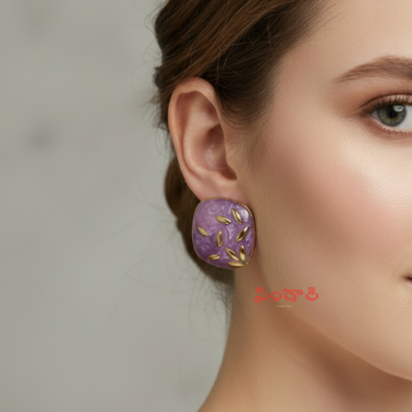 Close-up of a woman wearing a purple earring with gold accents against a neutral background