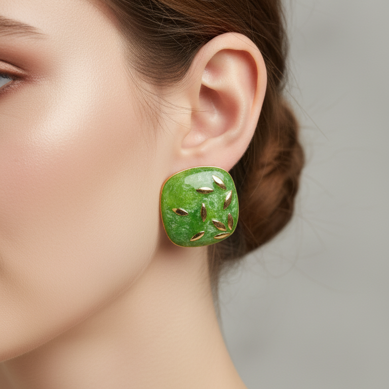 Green earrings worn by a model on a neutral background