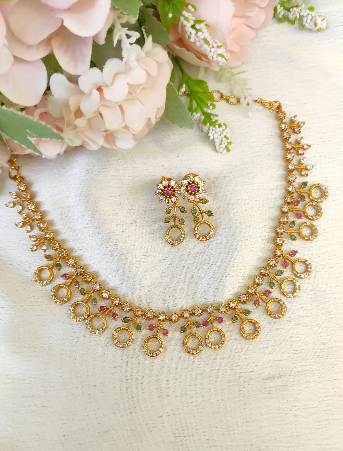 American diamond necklace and matching earrings set adorned with small multicolored ruby and emerald-like stones