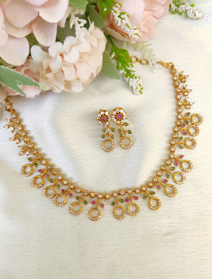 American diamond necklace and matching earrings set adorned with small multicolored ruby and emerald-like stones