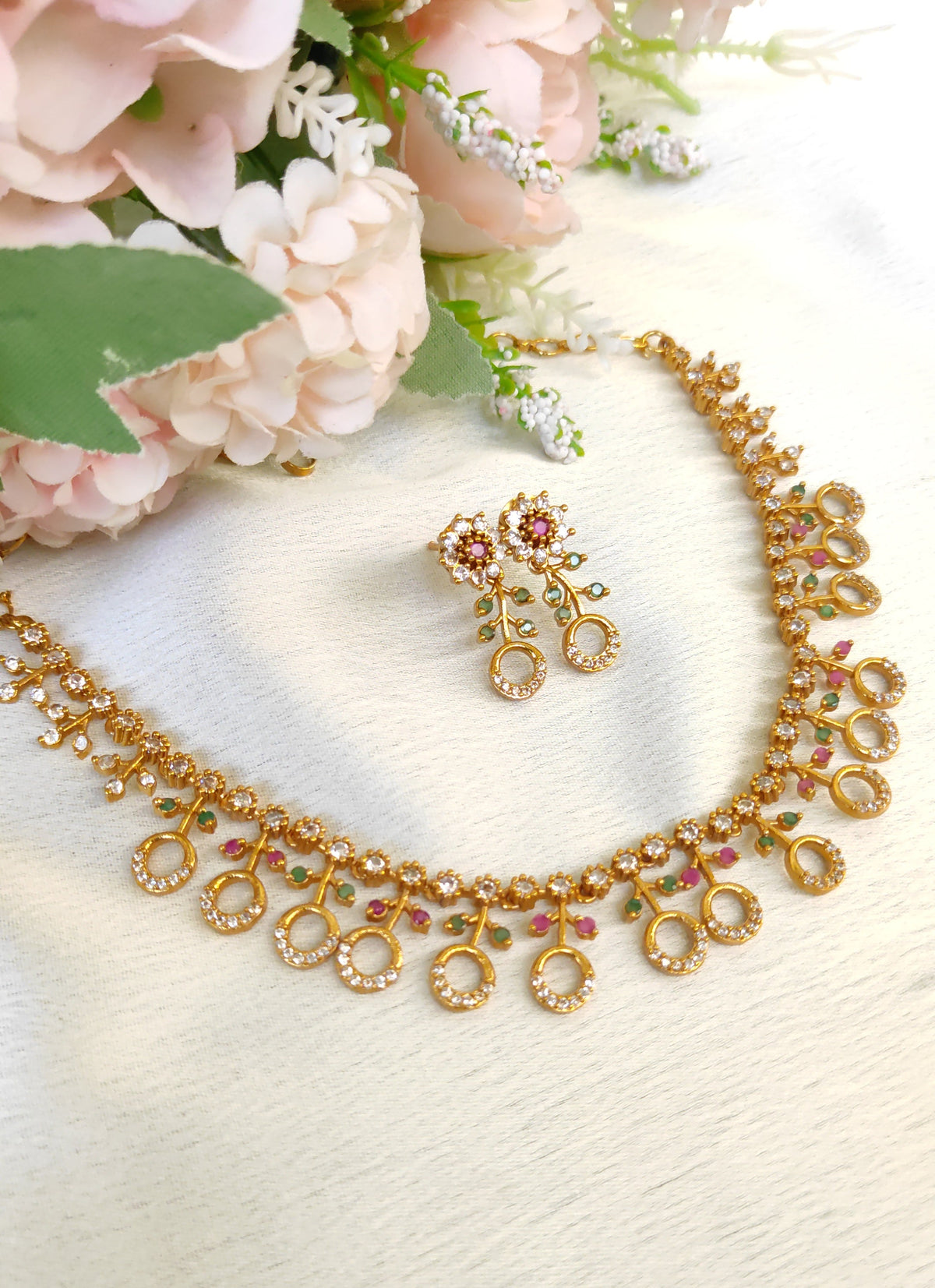 American diamond necklace and matching earrings set adorned with small multicolored ruby and emerald-like stones